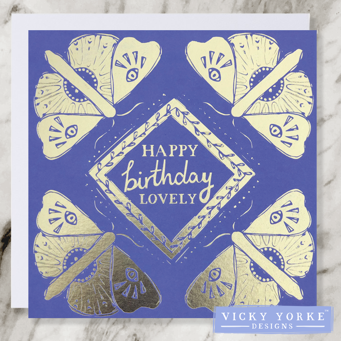 Purple and gold foil greetings card with happy birthday lovely sentiment surrounded by a diamond leaf border and a gold moth illustration in each corner.