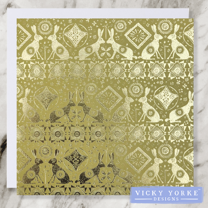 Yellow and gold foil greetings card with art nouveau style pattern featuring hares, suns and abstract geometric shapes.