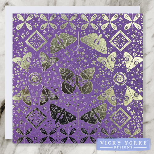 Purple and gold foil greetings card with moths, butterflies and flowers in a reflected pattern for decoration.