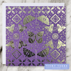 Purple and gold foil greetings card with moths, butterflies and flowers in a reflected pattern for decoration.